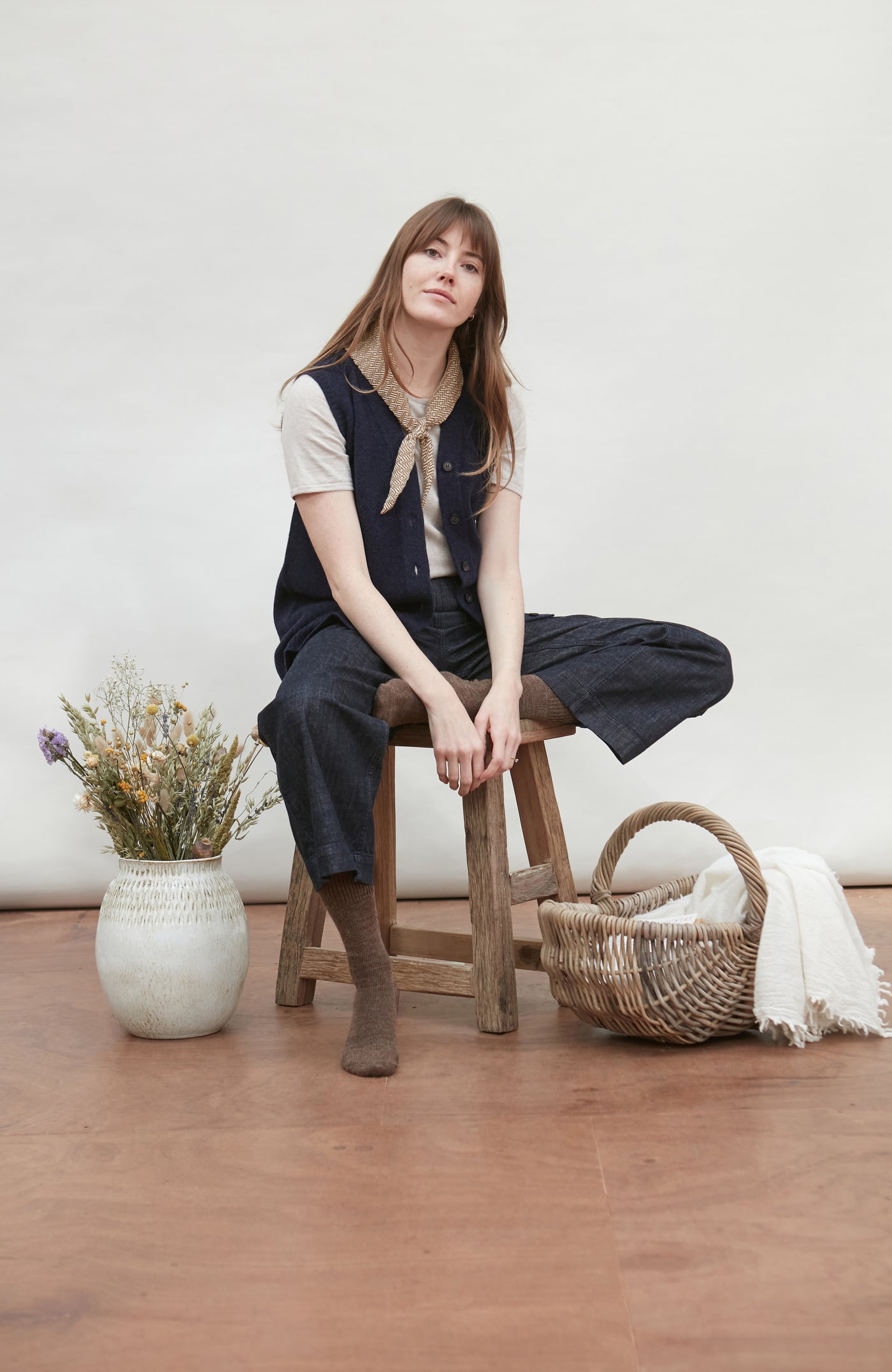 Woman wearing a navy wool vest and with a beige bow