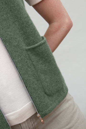 Green wool gilet by paul james with a zipper on a neutral background