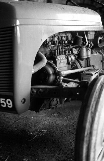 Black and white close-up photograph of a vintage tractor engine and front wheel, with the number 59 visible on the side by Paul James Knitwear