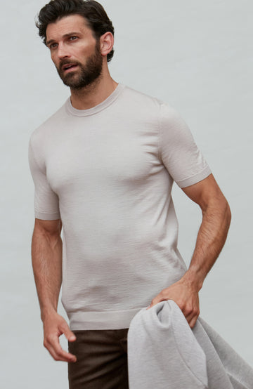 Man wearing a beige fine wool silk luxury t-shirt by Paul James against a plain background