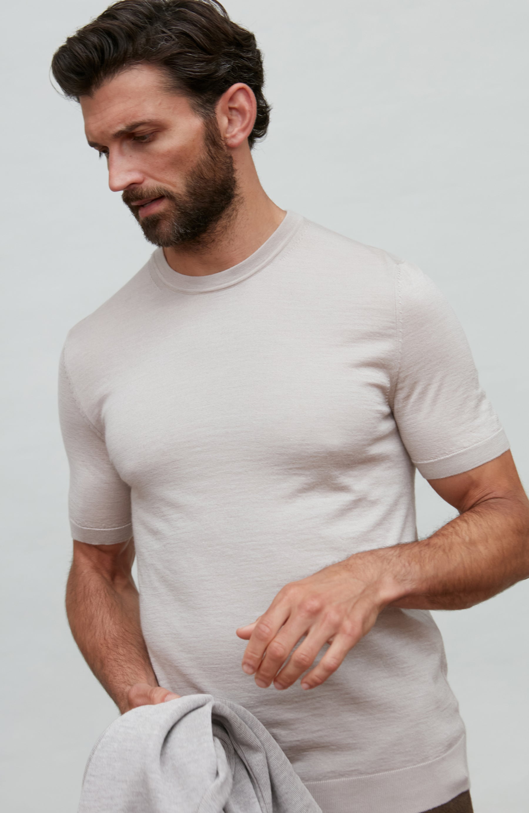 Man wearing a beige fine wool silk luxury t-shirt by Paul James against a plain background