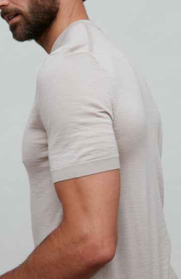 Man wearing a beige fine wool silk luxury t-shirt by Paul James against a plain background