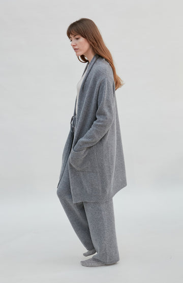 woman wearing a gray longline wool cardigan outfit on a white background by Paul James