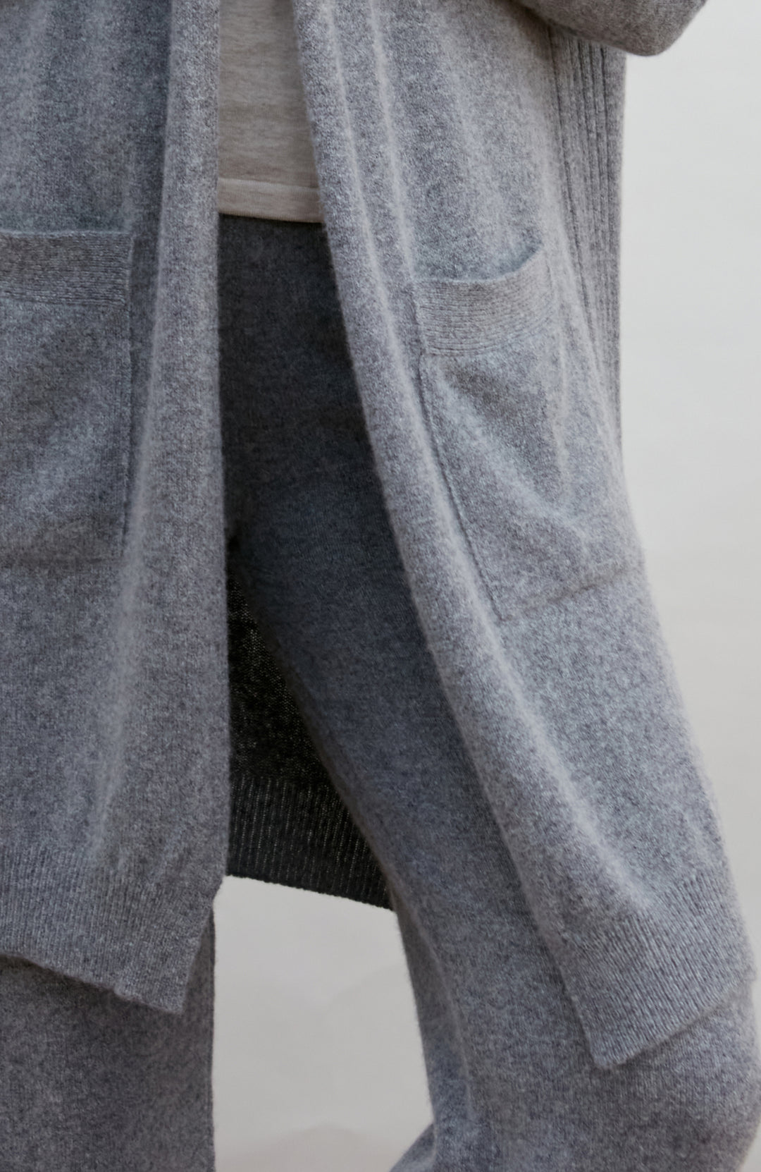 Gray cardigan worn by a person on a white background by Paul James