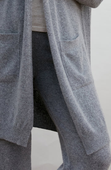 Gray cardigan worn by a person on a white background by Paul James
