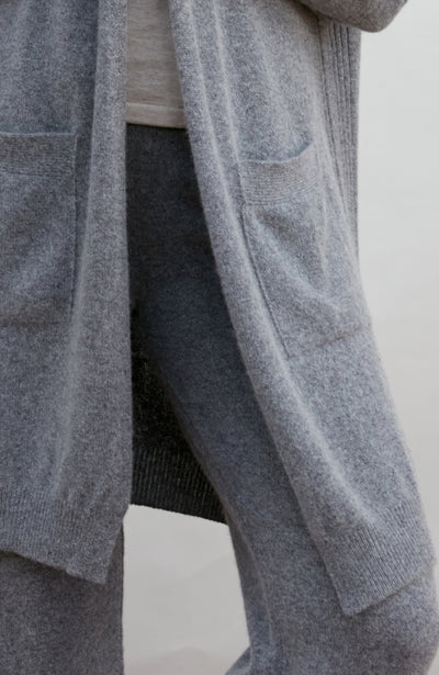 Gray cardigan worn by a person on a white background