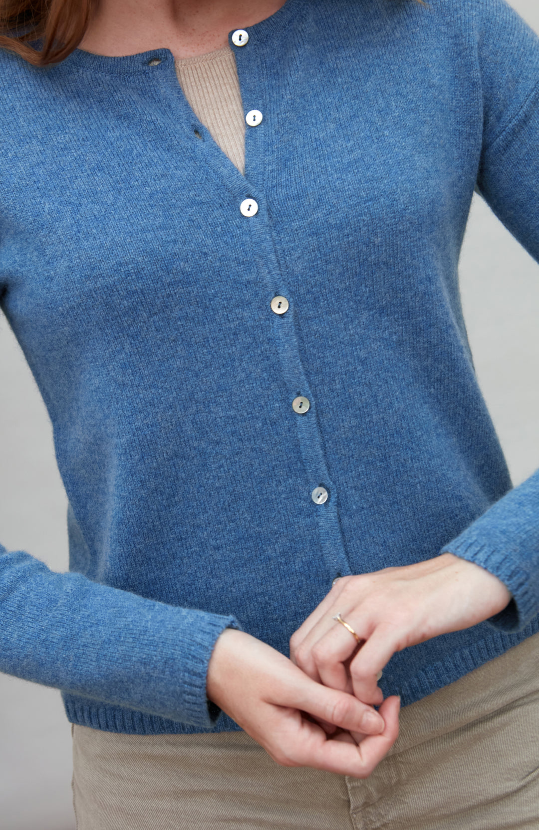Blue wool cardigan worn by a person on a gray background by Paul James