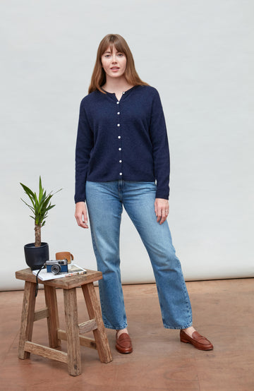 Woman wearing a navy blue lambswool wool cardigan by Paul James