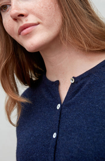 Woman wearing a navy blue wool cardigan close up by paul james