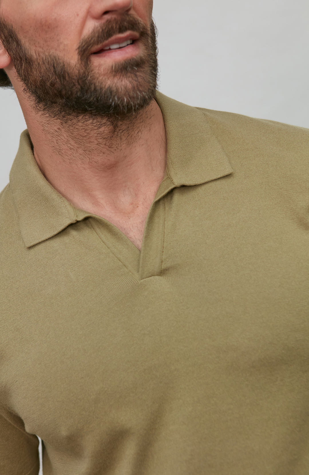 Man wearing a beige long-sleeve shirt against a plain background
