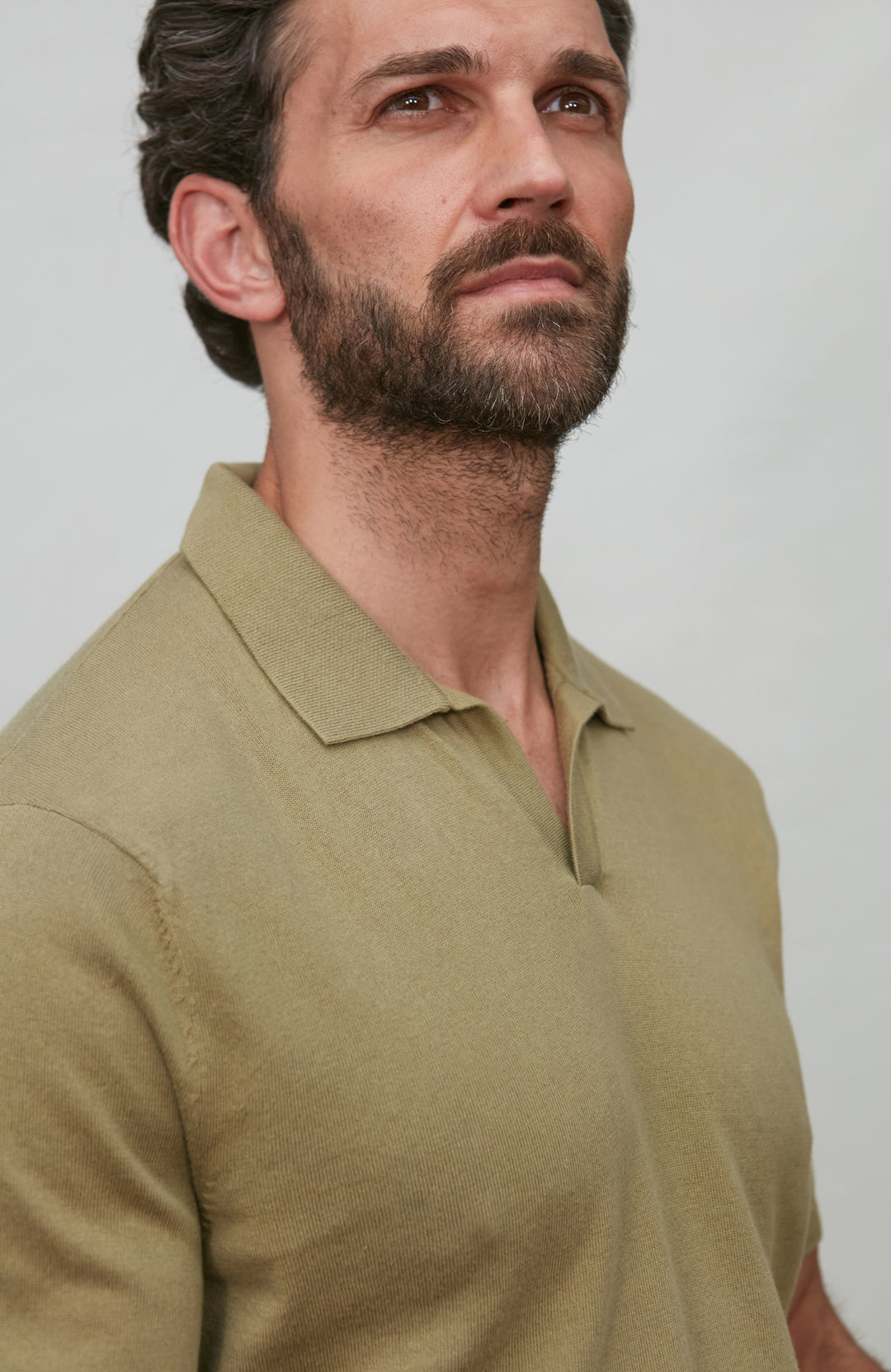 Man wearing a green polo shirt against a plain background