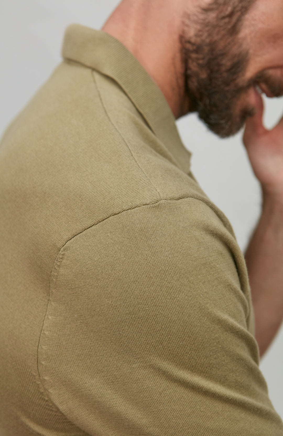 Close-up of a person wearing a green shirt with a blurred background