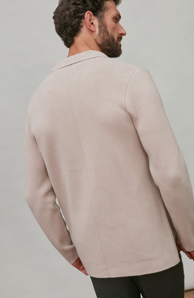 Man wearing a beige jacket against a plain background