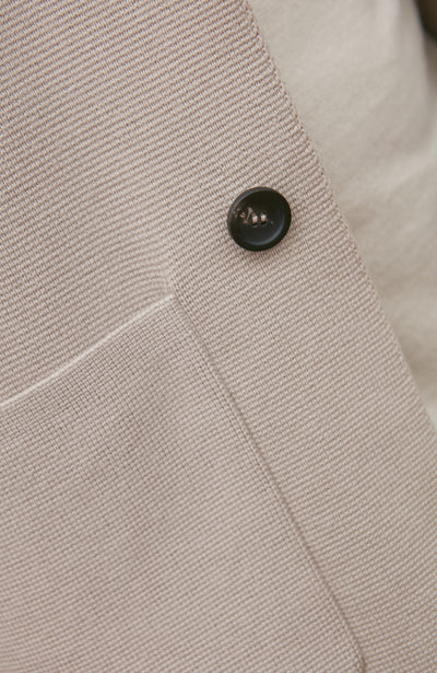 Close-up of a button on a beige fabric surface