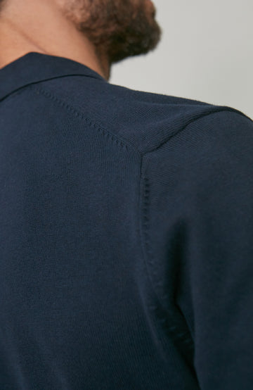 Navy blue cotton polo shirt worn by a person on a plain background