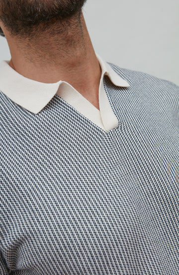 buttonless polo Close-up of a person wearing a patterned shirt with a white collar.