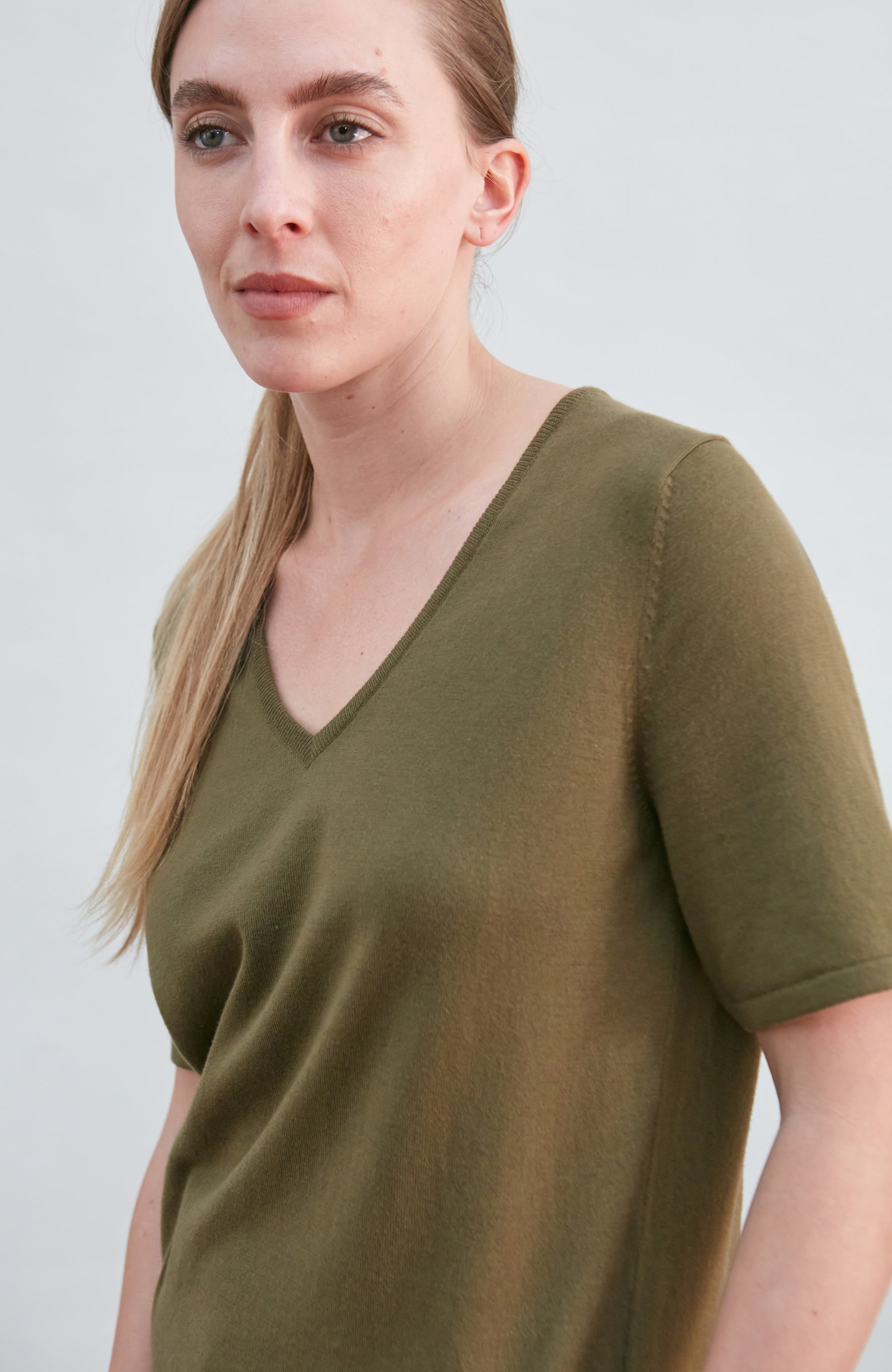 Woman wearing a dark green knitted-shirt by paul james