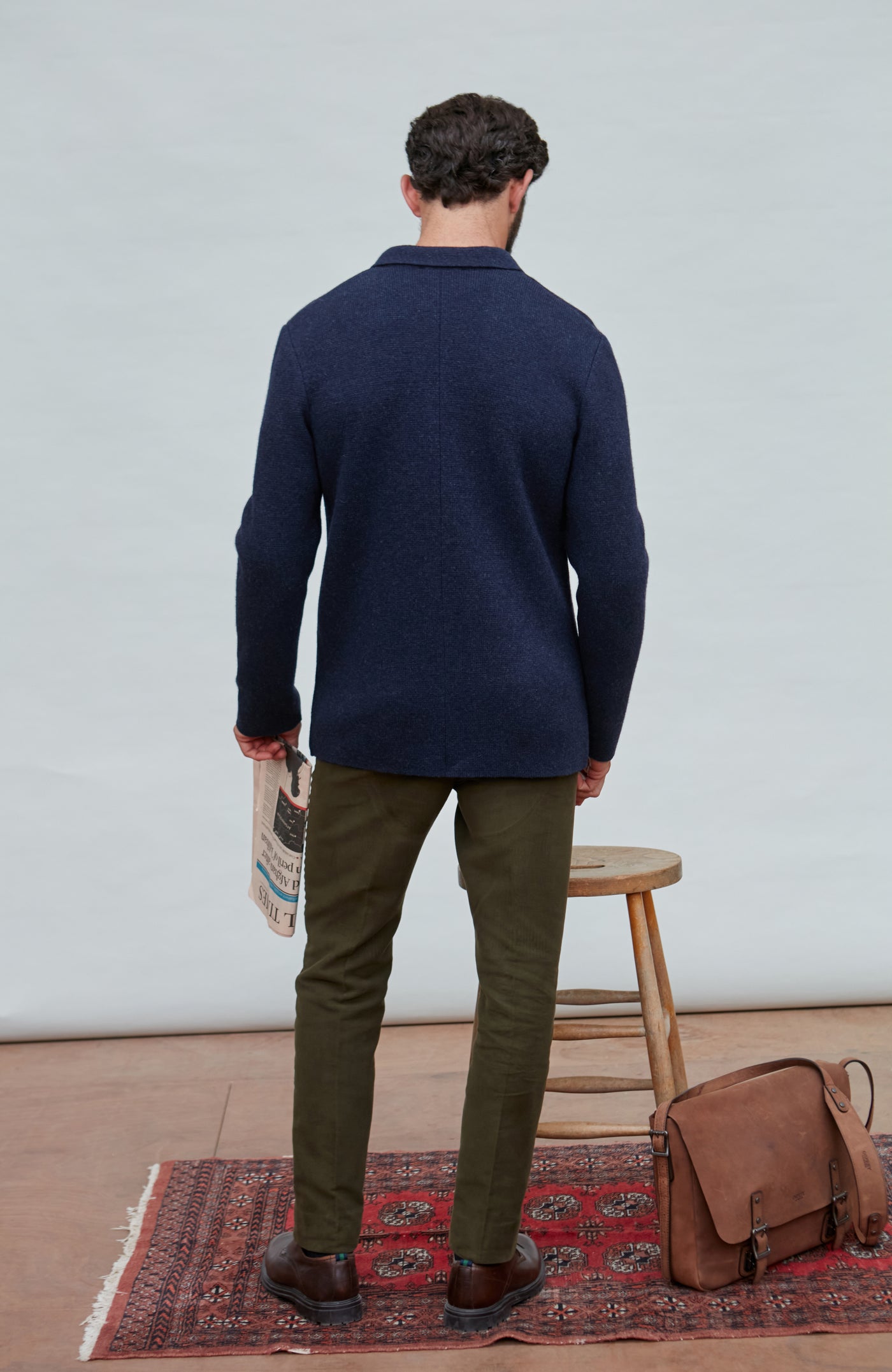 Man wearing a blue wool blazer over a white shirt with a light gray background