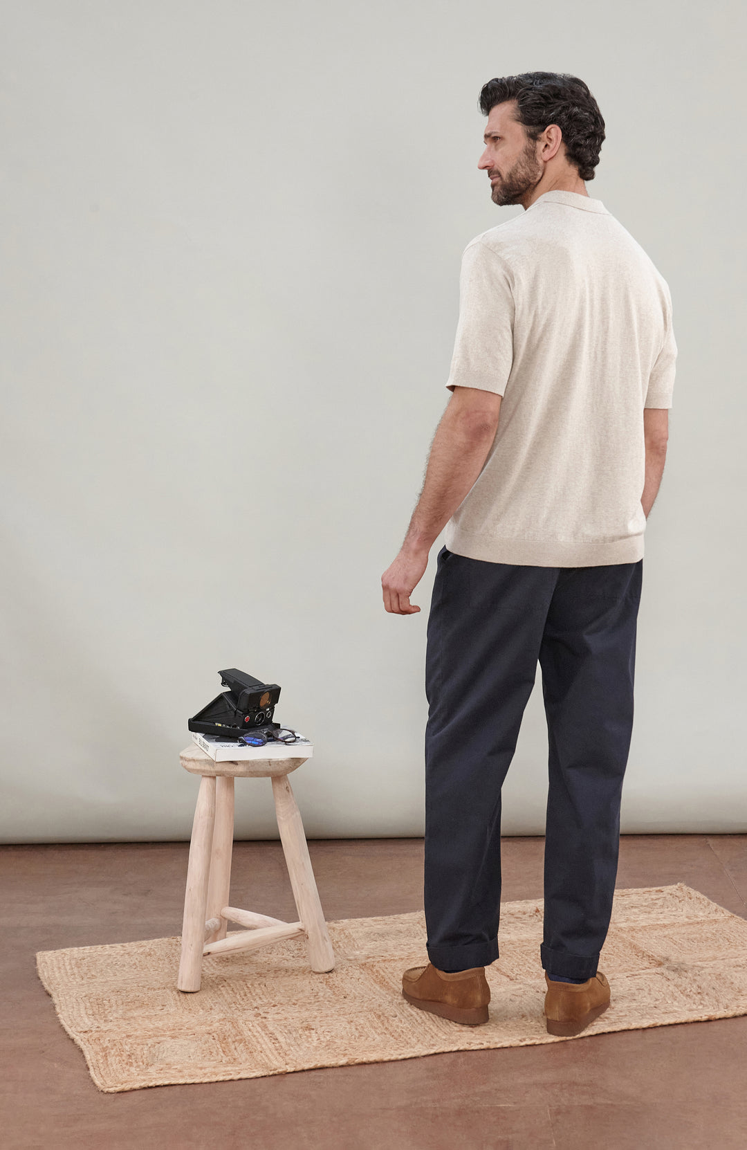 A man in wearing a light beige cotton knit short-sleeve polo shirt by Paul James Knitwear
