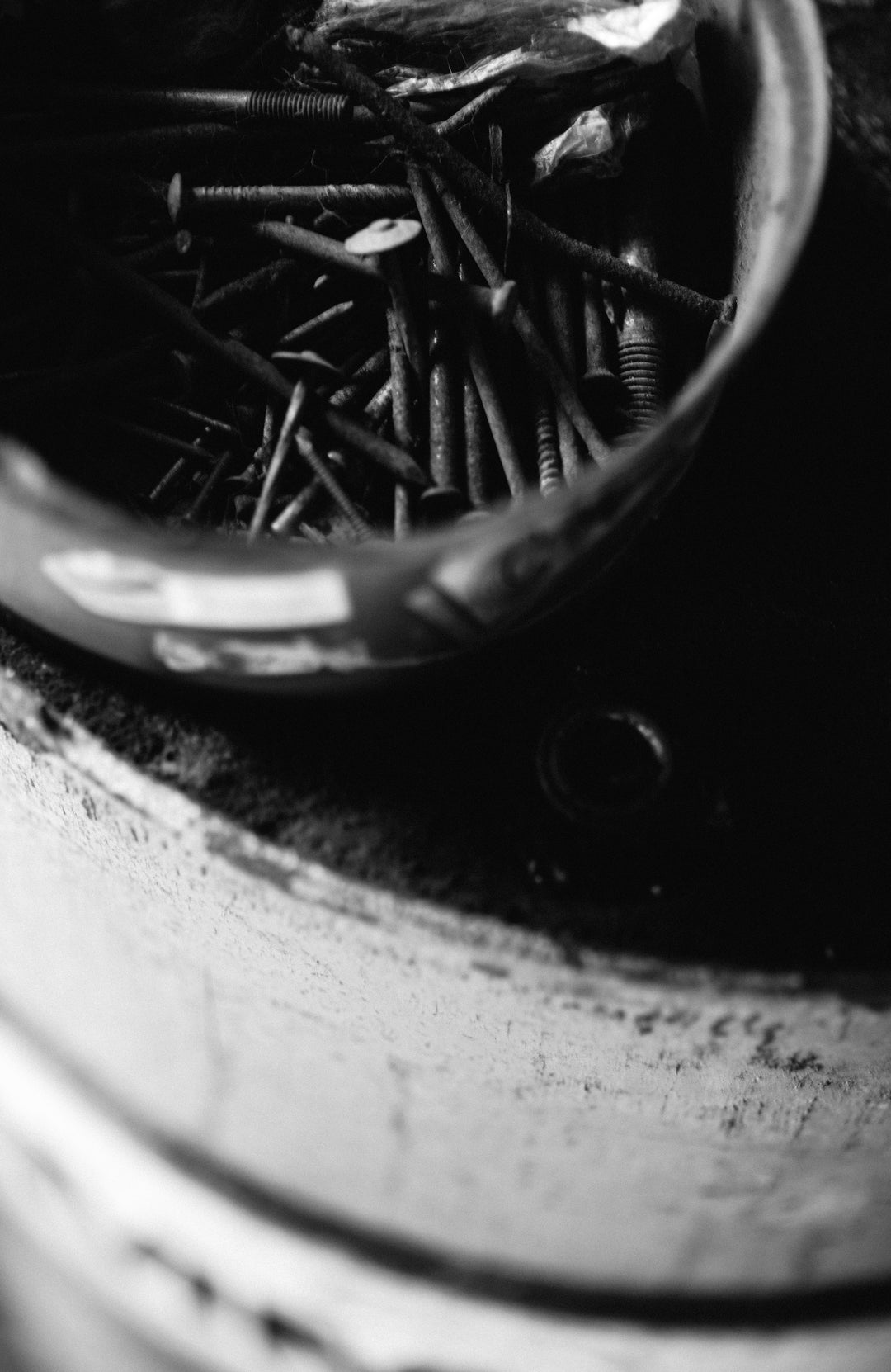 Close-up of a container filled with nails on a dark surface