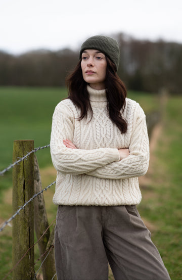 Woman wearing chunky merino wool turtle neck sweater made in England by Paul James Knitwear