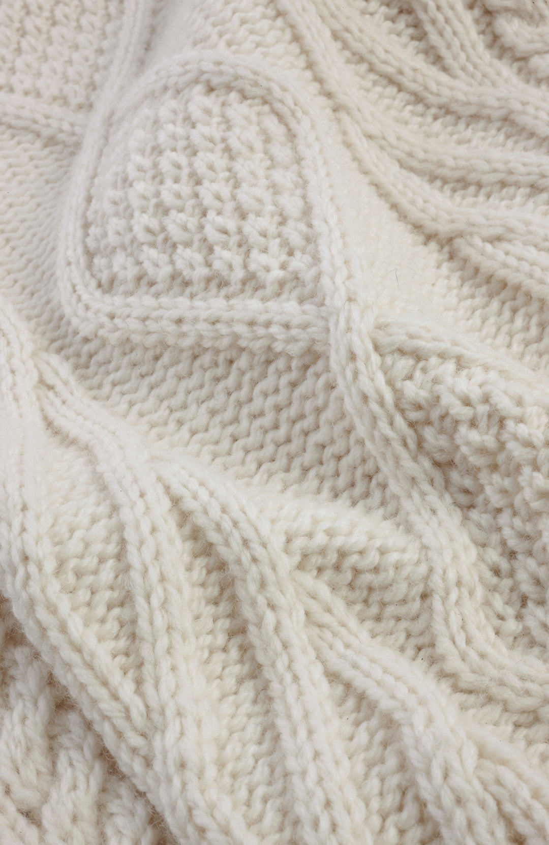 Chunky merino wool jumper made in England by Paul James Knitwear. Close-up knitted swatch and cable pattern