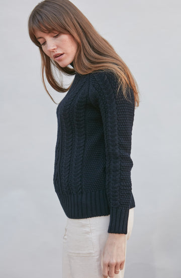 Womens wearing navy chunky wool cable sweater by Paul James
