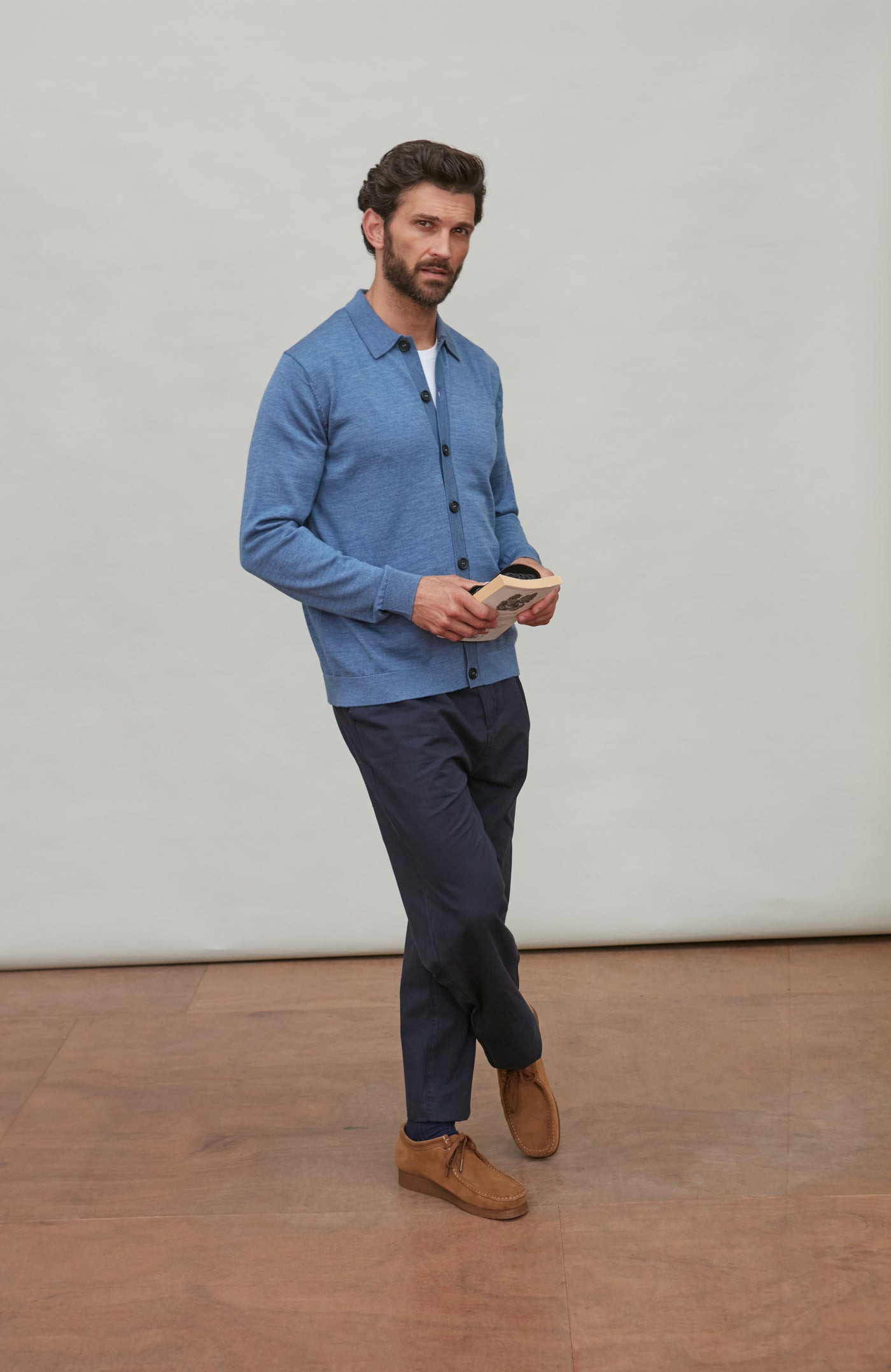 Man wearing a denim blue merino wool button-up shirt against a gray background