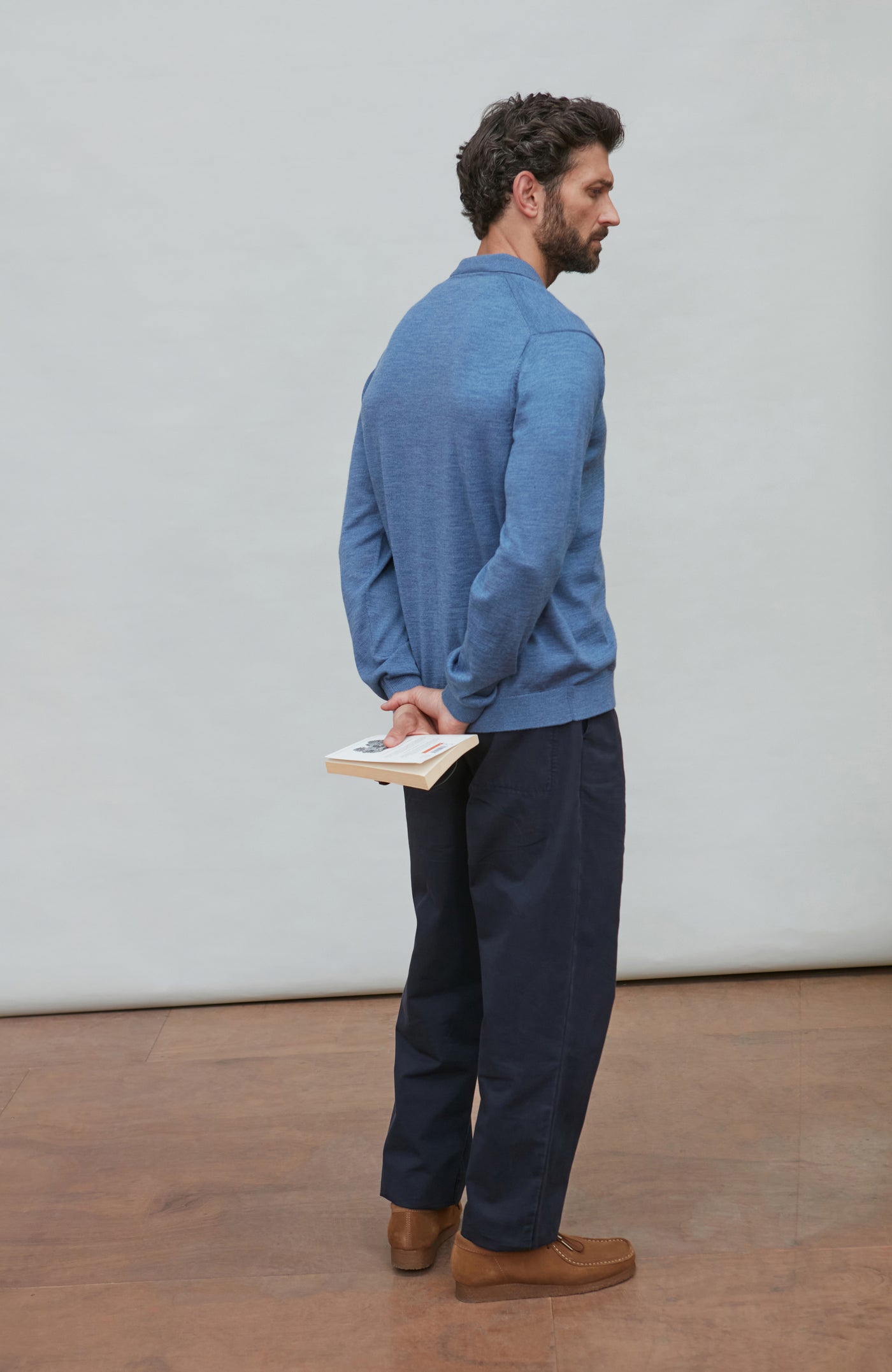 Man wearing a denim blue merino wool button-up shirt against a gray background