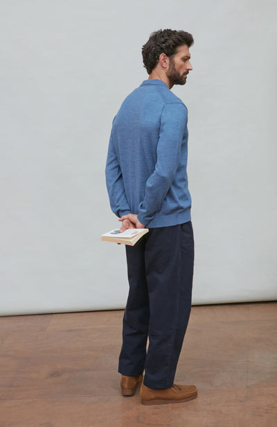 Man wearing a denim blue merino wool button-up shirt against a gray background