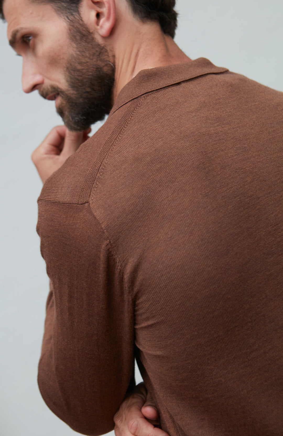 Man wearing a brown fine wool shirt against a light gray background by Paul James