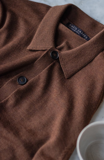 Brown polo shirt with 'Paul James' logo on collar, close-up shot.