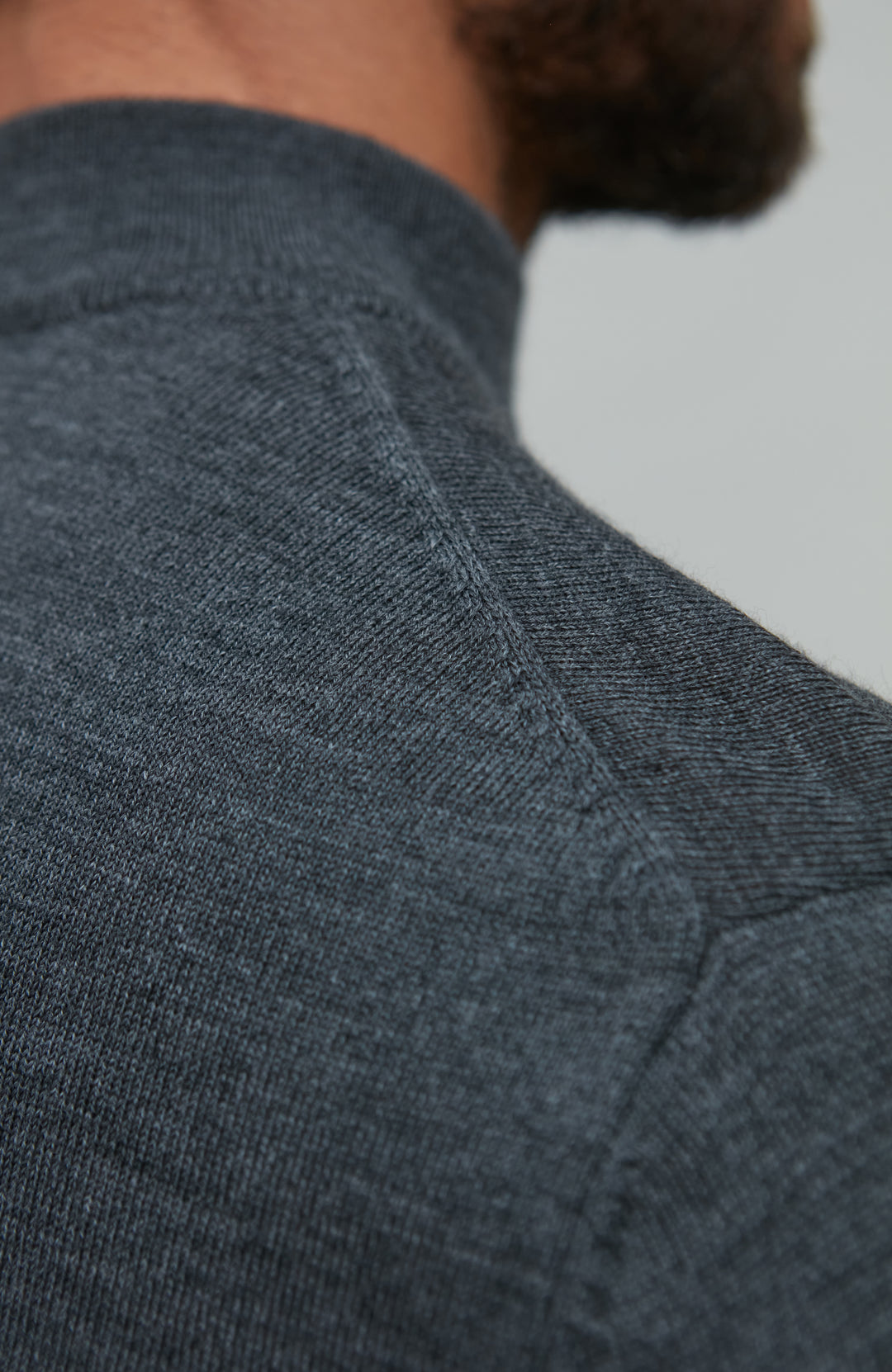 Man wearing a dark gray merino wool turtle neck sweater by Paul James