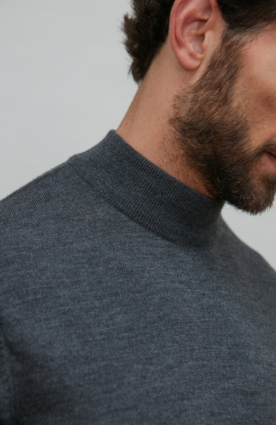Man wearing a dark gray merino wool turtle neck sweater by Paul James