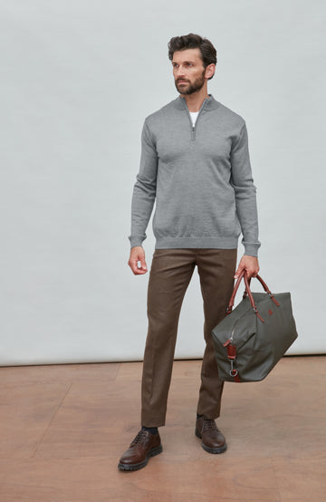 Man wearing a gray fine merino wool quarter-zip sweater against a light gray background
