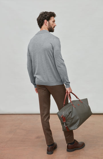 Man wearing a gray fine merino wool quarter-zip sweater against a light gray background