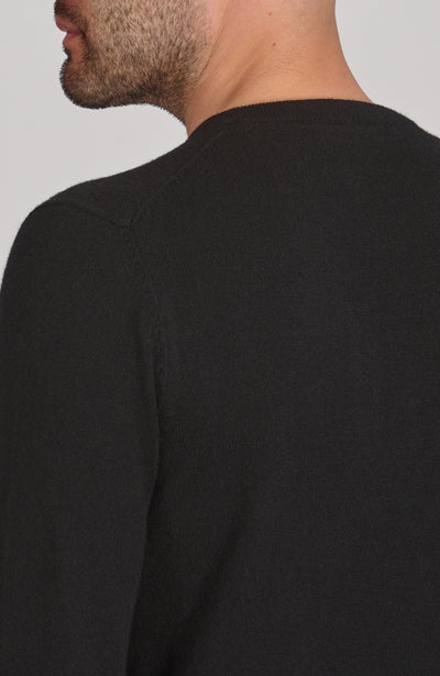 Black merino cashmere sweater worn by a person on a plain background