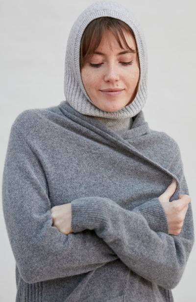 woman wearing a gray merino cashmere balaclava against a plain background